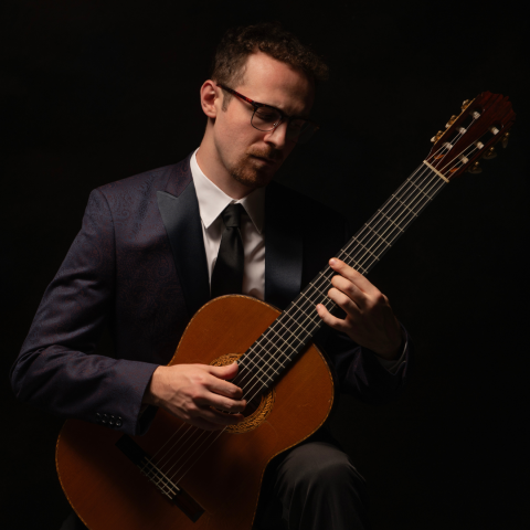 Bearded man holding a guitar