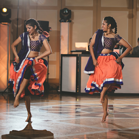 Two dancers with red skirts on a stage